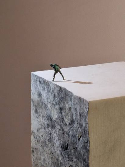 opera in marmo con omino di bronzo in cima