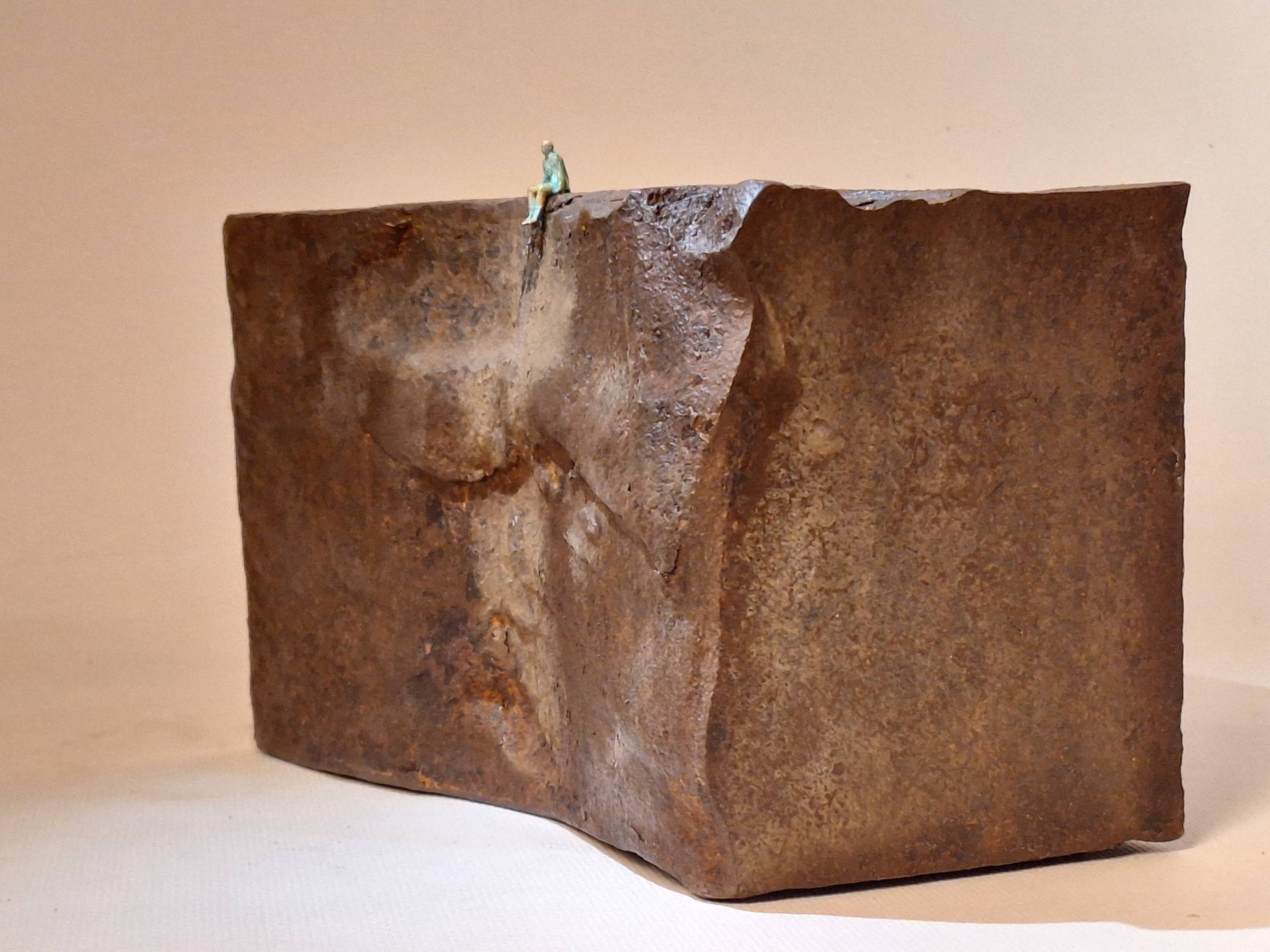 opera scultorea realizzata con un blocchetto di ferro e un omino di bronzo in cima