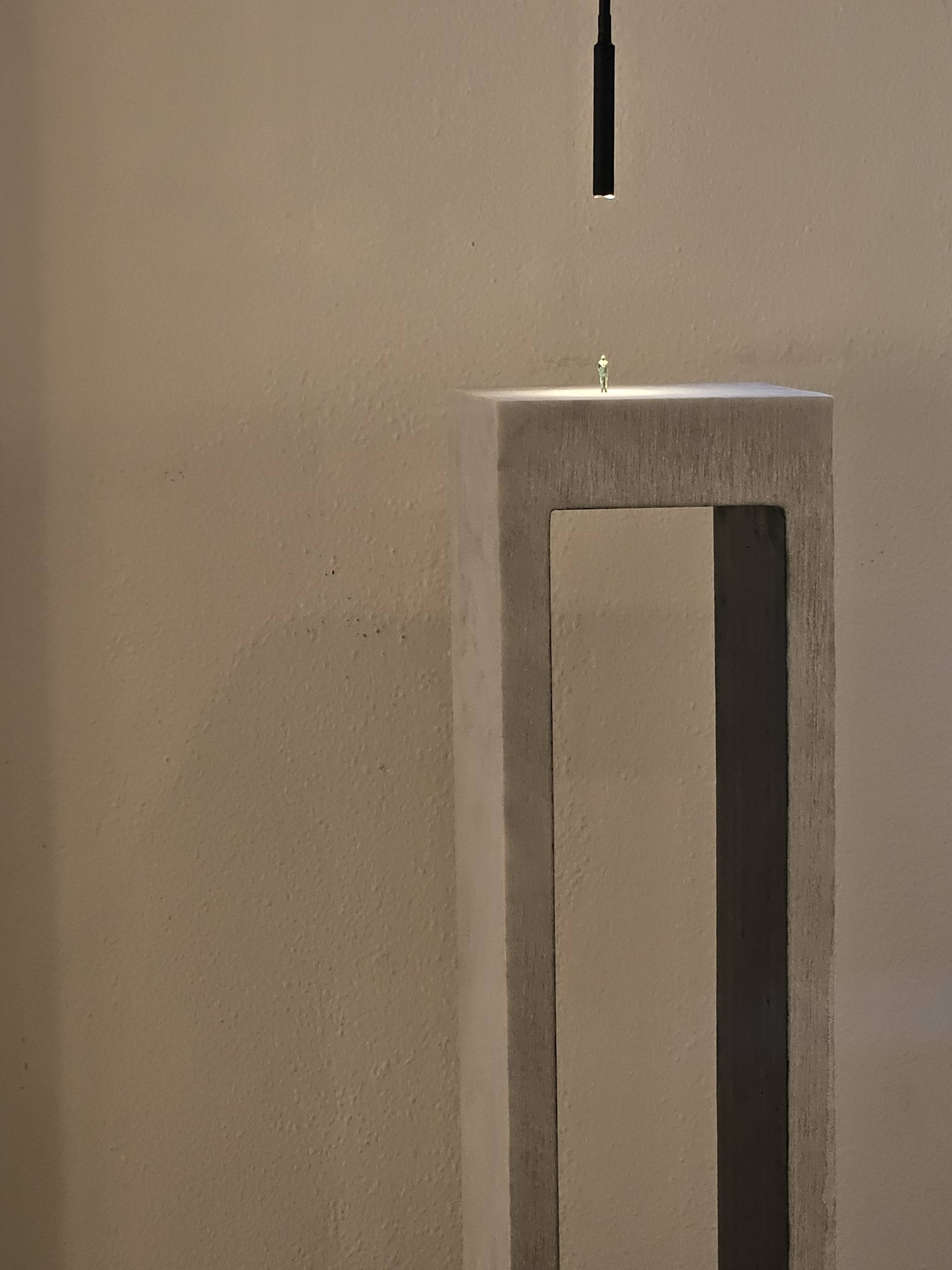 opera in marmo a forma di ponte con omino di bronzo in cima