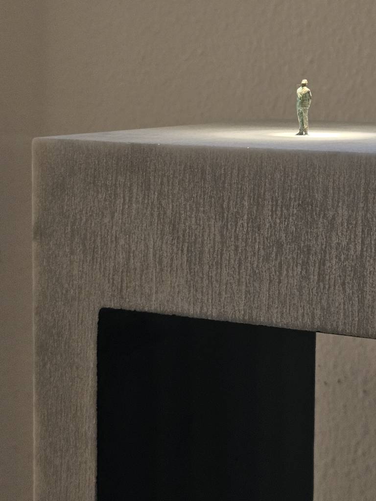 opera in marmo a forma di ponte con omino di bronco in cima