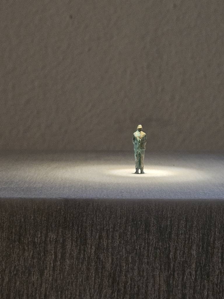 opera in marmo a forma di ponte con omino di bronco in cima