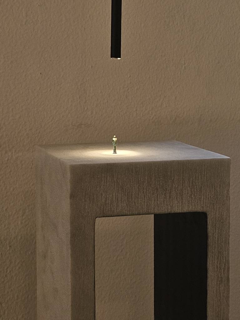 opera in marmo a forma di ponte con omino di bronco in cima